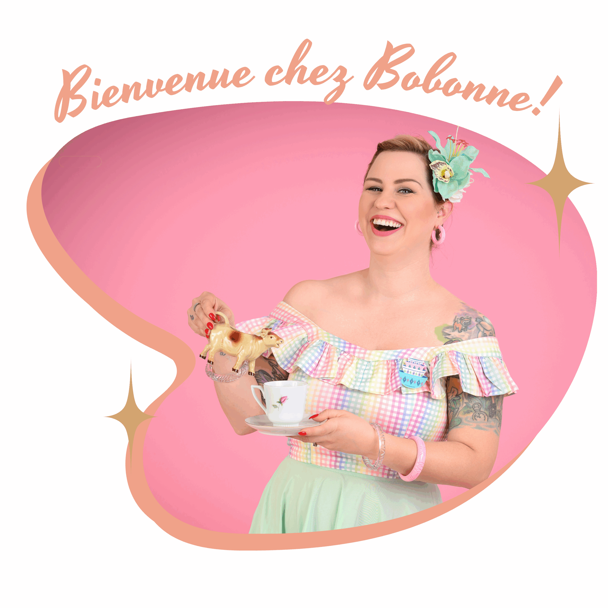 femme habillée en pinup tient un bébé et une box en kraft dans les bras. Elles sont toutes les deux très souriantes.